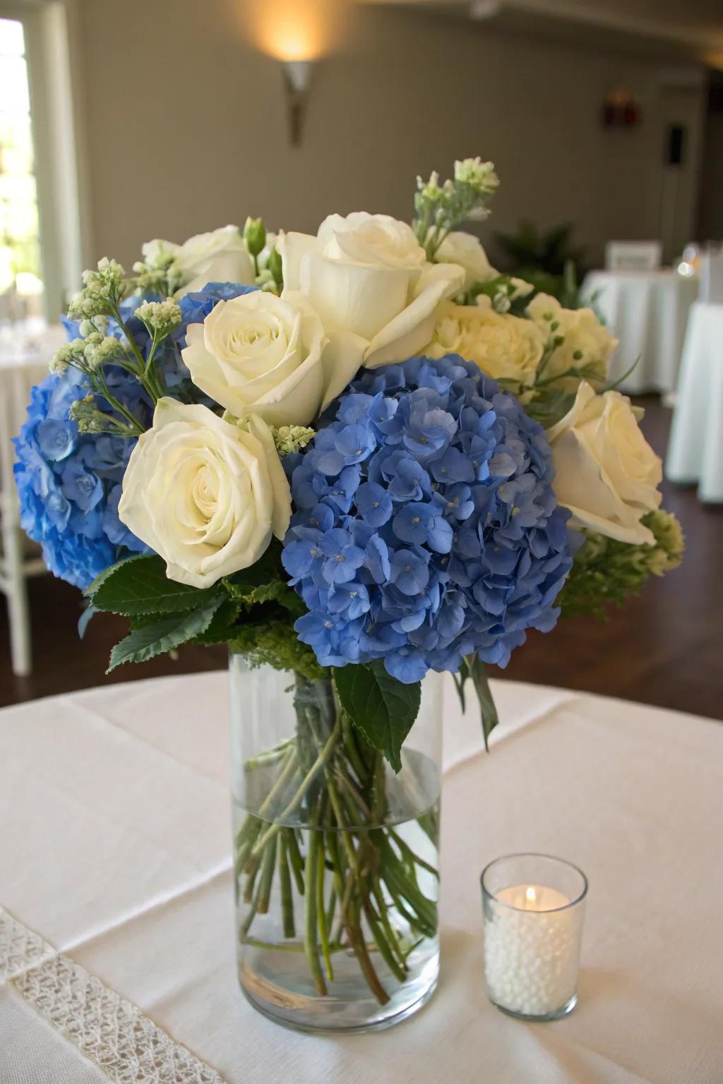 A lush floral arrangement with royal blue hydrangeas and white roses creates a stunning centerpiece.