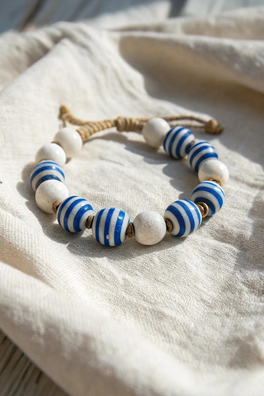 Embrace the nautical charm of summer with this beautifully crafted blue and white striped clay bead bracelet. Perfect for adding a touch of elegance to any outfit.