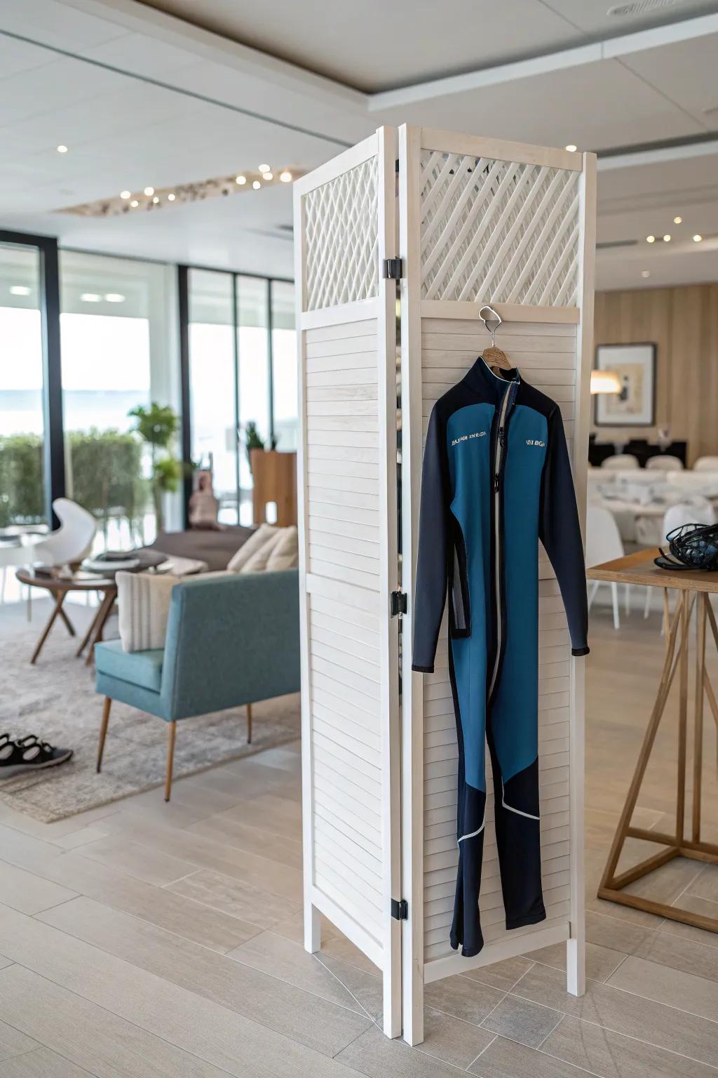 A folding screen used as a backdrop for a drying wetsuit in a stylish room.
