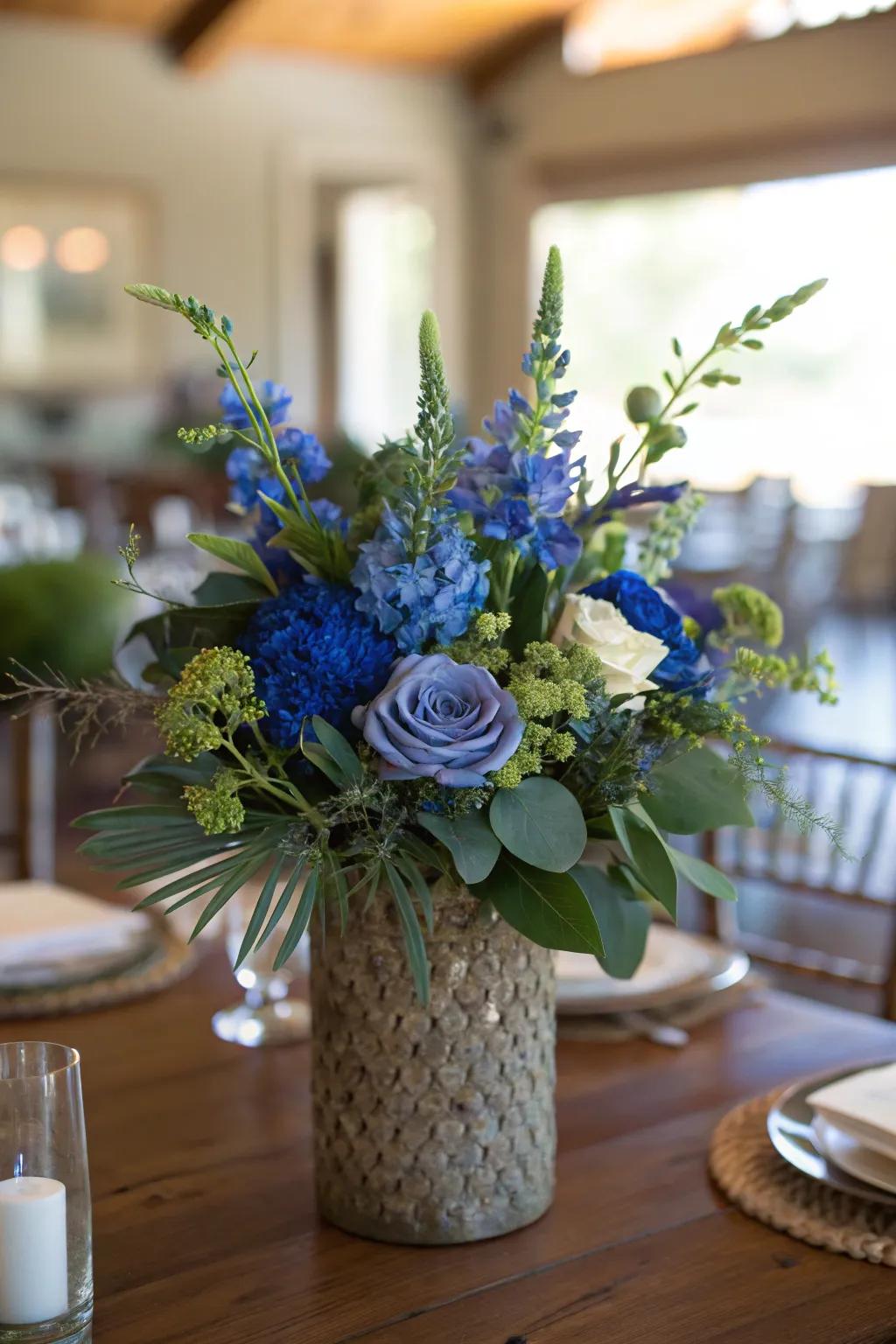 Combining royal blue flowers with greenery creates a natural and vibrant centerpiece.