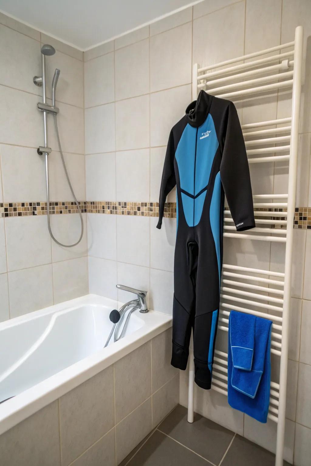 A wetsuit hanging on a towel rack in a bathroom setting.